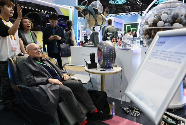 (251108) -- SHANGHAI, Nov. 8, 2025 (Xinhua) -- A guest tries Scent TV at the China Pavilion during the eighth China International Import Expo (CIIE) in east China's Shanghai, Nov. 8, 2025. Over 30 foreign talents and their families were invited to visit the eighth CIIE at the National Convention and Exhibition Center (Shanghai) during a themed event on Saturday. (Xinhua/Fang Zhe)