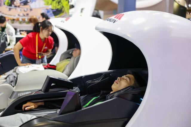 (251108) -- SHANGHAI, Nov. 8, 2025 (Xinhua) -- Visitors try massage chairs of Johnson Health Tech at the Consumer Goods Exhibition area during the eighth China International Import Expo (CIIE) in east China's Shanghai, Nov. 8, 2025. At the Consumer Goods Exhibition area of the eighth CIIE, apparel, daily chemicals, home furnishings, and cultural and sports products were prominently showcased, reflecting global consumption trends and improvements in quality of life. (Xinhua/Wang Zecong)