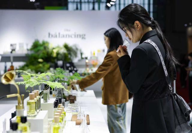 (251108) -- SHANGHAI, Nov. 8, 2025 (Xinhua) -- Visitors sample fragrances at a perfume brand booth at the Consumer Goods Exhibition area during the eighth China International Import Expo (CIIE) in east China's Shanghai, Nov. 8, 2025. At the Consumer Goods Exhibition area of the eighth CIIE, apparel, daily chemicals, home furnishings, and cultural and sports products were prominently showcased, reflecting global consumption trends and improvements in quality of life. (Xinhua/Wang Zecong)