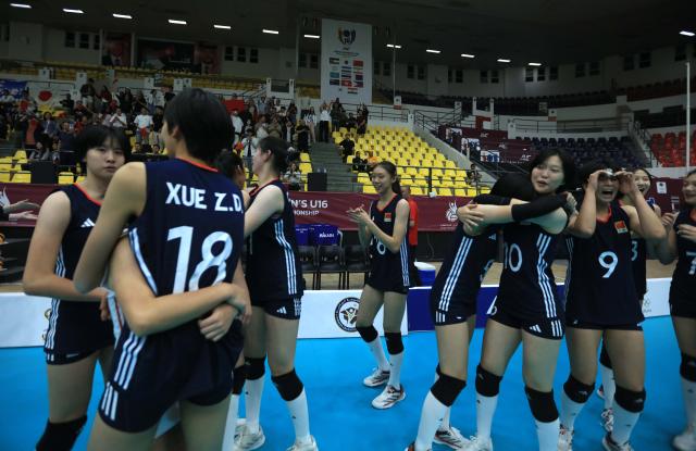 (251109) -- AMMAN, Nov. 9, 2025 (Xinhua) -- Players of China hug each other after winning the bronze medal match between China and Japan at the 2nd Asian Women's U16 Volleyball Championship in Amman, Jordan, Nov. 8, 2025. (Photo by Mohammad Abu Ghosh/Xinhua)