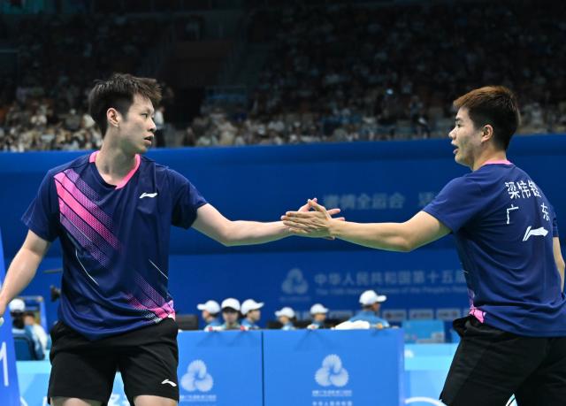 (251109) -- SHENZHEN, Nov. 9, 2025 (Xinhua) -- Liang Weikeng (R)/Ren Xiangyu of Guangdong celebrate scoring in the match against He Jiting/Lin Xiangyi of Fujian during the men's team group match of badminton at China's 15th National Games in Shenzhen, south China's Guangdong Province, Nov. 9, 2025. (Xinhua/Li He)