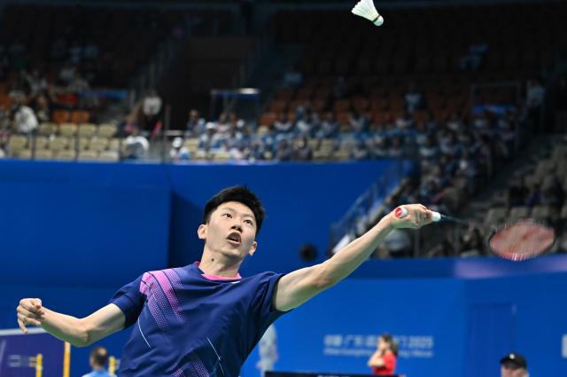(251109) -- SHENZHEN, Nov. 9, 2025 (Xinhua) -- Lei Lanxi of Guangdong hits a return to Weng Hongyang of Fujian during the men's team group match of badminton at China's 15th National Games in Shenzhen, south China's Guangdong Province, Nov. 9, 2025. (Xinhua/Li He)