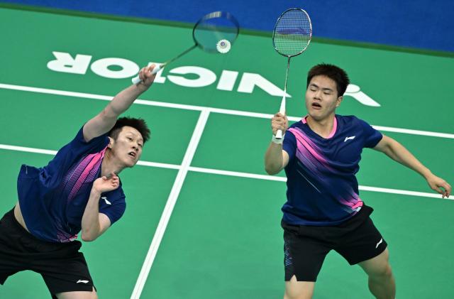 (251109) -- SHENZHEN, Nov. 9, 2025 (Xinhua) -- Liang Weikeng (R)/Ren Xiangyu of Guangdong compete against He Jiting/Lin Xiangyi of Fujian during the men's team group match of badminton at China's 15th National Games in Shenzhen, south China's Guangdong Province, Nov. 9, 2025. (Xinhua/Li Ziheng)