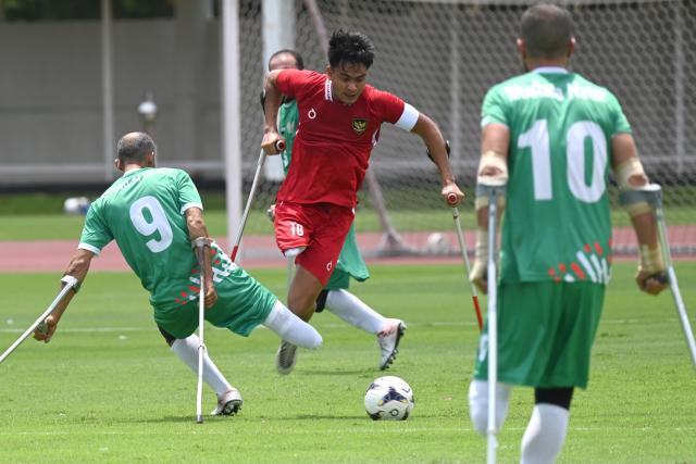 (251109) -- JAKARTA, Nov. 9, 2025 (Xinhua) -- Aditya Adit (C) of Indonesia vies with Ahmad Alkhatib (L) of Syria during Group A match between Indonesia and Syria at the Asian Amputee Football Cup Qualifiers 2025 in Jakarta, Indonesia, Nov. 9, 2025. (Xinhua/Agung Kuncahya B.)