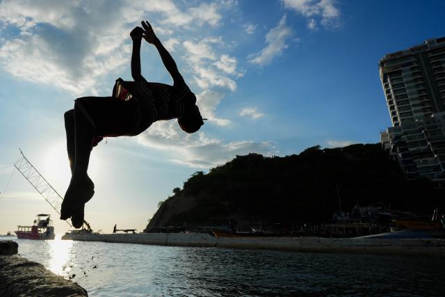 (251109) -- SANTA MARTA, Nov. 9, 2025 (Xinhua) -- A boy jumps into the sea at a small boat port in Santa Marta, Colombia, Nov. 8, 2025.
  The Colombian city of Santa Marta hosts the 4th CELAC (the Community of Latin American and Caribbean States)-EU (European Union) Summit from Nov. 9 to 10. (Photo by Andres Moreno/Xinhua)