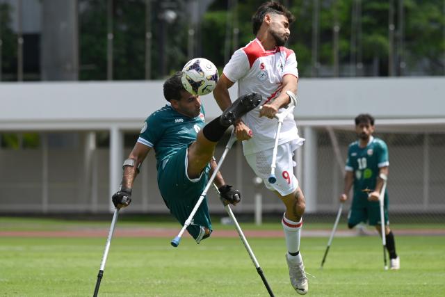 (251109) -- JAKARTA, Nov. 9, 2025 (Xinhua) -- Abdullah Anood Sabr Al-Azerj (L) of Iraq vies with Mohammad Alitabar Firouzjah of Iran during the Group A match between Iran and Iraq at the Asian Amputee Football Cup Qualifiers 2025 in Jakarta, Indonesia, Nov. 9, 2025. (Xinhua/Agung Kuncahya B.)
