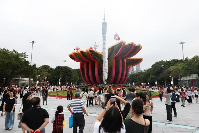 (251109) -- GUANGZHOU, Nov. 9, 2025 (Xinhua) -- People take photos of the Canton Tower in Guangzhou, south China's Guangdong Province, Nov. 9, 2025. The opening ceremony of China's 15th National Games will be held on Sunday evening in Guangzhou. (Xinhua/Wang Kaiyan)