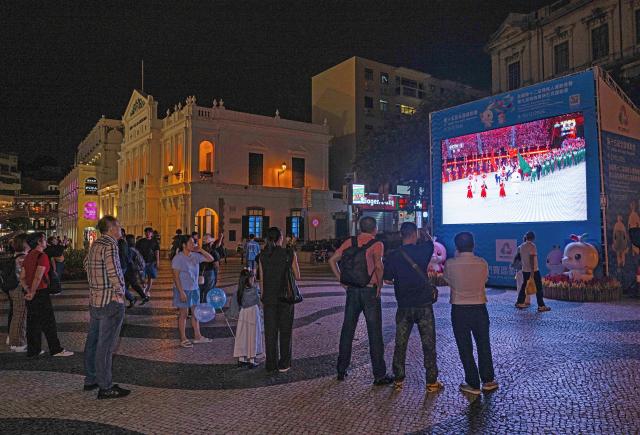 (251109) -- MACAO, Nov. 9, 2025 (Xinhua) -- People watch the live television broadcast of the opening ceremony of China's 15th National Games in Macao, south China, Nov. 9, 2025. The opening ceremony of China's 15th National Games was held on Sunday evening in Guangzhou, south China's Guangdong Province. (Xinhua/Cheong Kam Ka)