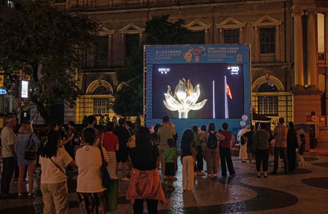 (251109) -- MACAO, Nov. 9, 2025 (Xinhua) -- People watch the live television broadcast of the opening ceremony of China's 15th National Games in Macao, south China, Nov. 9, 2025. The opening ceremony of China's 15th National Games was held on Sunday evening in Guangzhou, south China's Guangdong Province. (Xinhua/Cheong Kam Ka)