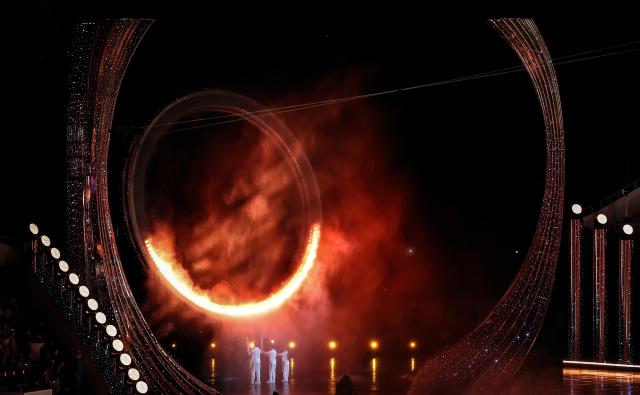 (251109) -- GUANGDONG, Nov. 9, 2025 (Xinhua) -- Torchbearers light the cauldron during the opening ceremony of China's 15th National Games in Guangzhou, south China's Guangdong Province, Nov. 9, 2025. (Xinhua/Lu Hanxin)