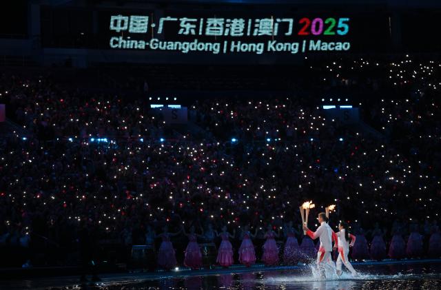 (251109) -- GUANGZHOU, Nov. 9, 2025 (Xinhua) -- Torchbearers take part in the torch relay during the opening ceremony of China's 15th National Games in Guangzhou, south China's Guangdong Province, Nov. 9, 2025. (Xinhua/Zhang Long)