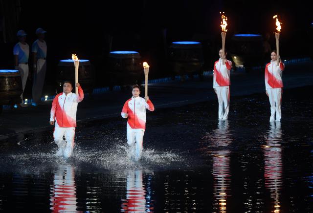 (251109) -- GUANGZHOU, Nov. 9, 2025 (Xinhua) -- Torchbearers take part in the torch relay during the opening ceremony of China's 15th National Games in Guangzhou, south China's Guangdong Province, Nov. 9, 2025. (Xinhua/Huang Wei)
