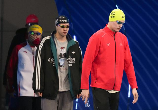 (251110) -- SHENZHEN, Nov. 10, 2025 (Xinhua) -- Sun Yang (R) and Pan Zhanle (C) of Zhejiang enter the venue before the men's 400m freestyle preliminary of swimming event at China's 15th National Games in Shenzhen, south China's Guangdong Province, Nov. 10, 2025. (Xinhua/Xia Yifang)