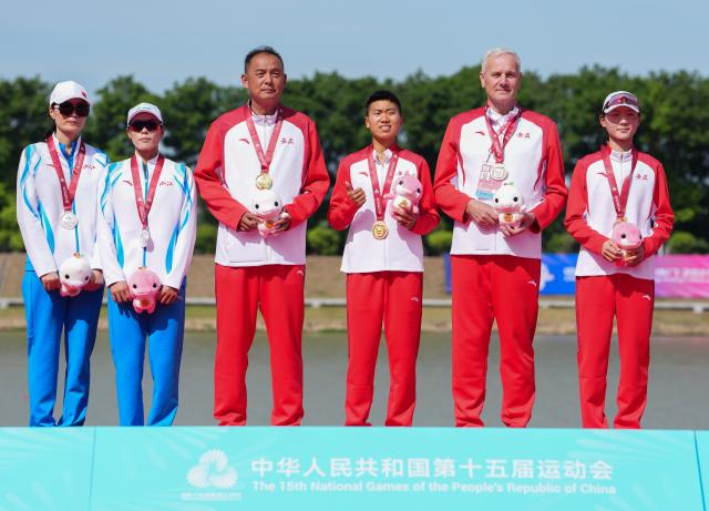 (251110) -- GUANGZHOU, Nov. 10, 2025 (Xinhua) -- Gold medalist Zhang Fangfang (3rd R) of Anhui, silver medalist Pan Dandan (2nd L) of Zhejiang and bronze medalist Li Huiru (1st R) of Anhui pose with their coaches during the awarding ceremony after the women's lightweight single sculls final of rowing at China's 15th National Games in Guangzhou, south China's Guangdong Province, Nov. 10, 2025. (Xinhua/Xiao Ennan)