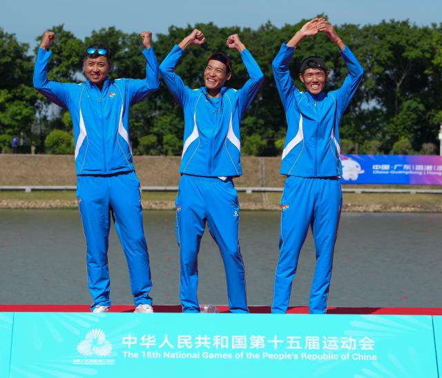 (251110) -- GUANGZHOU, Nov. 10, 2025 (Xinhua) -- Sun Man (C), Li Yawei (R) of Liaoning and their coach celebrate during the awarding ceremony after the women's lightweight double sculls final of rowing at China's 15th National Games in Guangzhou, south China's Guangdong Province, Nov. 10, 2025. (Xinhua/Xiao Ennan)