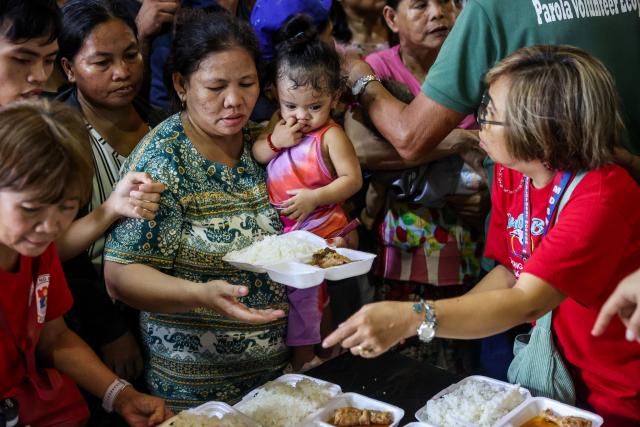 (251110) -- MANILA, Nov. 10, 2025 (Xinhua) -- Residents receive food provided by a local government unit inside an evacuation center as they take shelter from Super Typhoon Fung-wong in Manila, the Philippines, Nov. 10, 2025. Super Typhoon Fung-wong made landfall over Aurora province in the eastern part of Luzon Island of the Philippines on Sunday night, according to the state weather bureau.
   Fung-wong is the 21st tropical cyclone hitting the Philippines this year, surpassing the country's annual average of 20 storms. (Xinhua/Rouelle Umali)