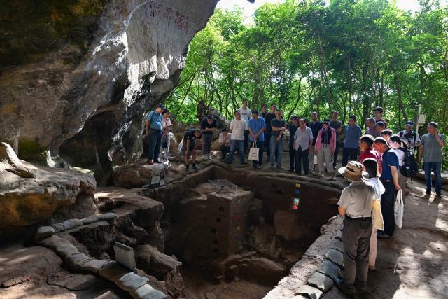 (251110) -- SANYA, Nov. 10, 2025 (Xinhua) -- Archaeologists observe the excavation site of the Luobi Cave relic site in Sanya, south China's Hainan Province, Nov. 8, 2025. A prehistoric tomb dating back between 12,000 and 13,000 years was discovered in south China's Hainan Province, which is believed to be the earliest tomb found on the island.
   The tomb, discovered at the Luobi Cave relic site in Sanya's Jiyang District, belonged to a child who was buried on his or her side with bent limbs. Shell ornaments were found near the head and waist, believed to be the earliest of their kind in China, offering valuable insights into Hainan's prehistoric culture and its cultural exchanges with Southeast Asia. (Xinhua/Guo Cheng)