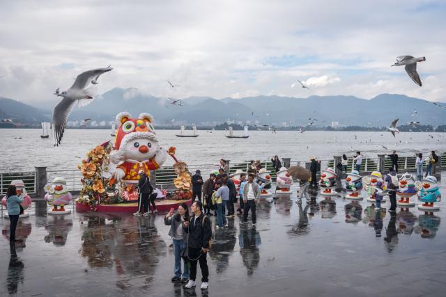 (251110) -- KUNMING, Nov. 10, 2025 (Xinhua) -- Tourists visit Haigeng Dam in Kunming, southwest China's Yunnan Province, Nov. 10, 2025. Black-headed gulls migrate to Kunming for the warm weather there in winter. (Xinhua/Wang Guansen)