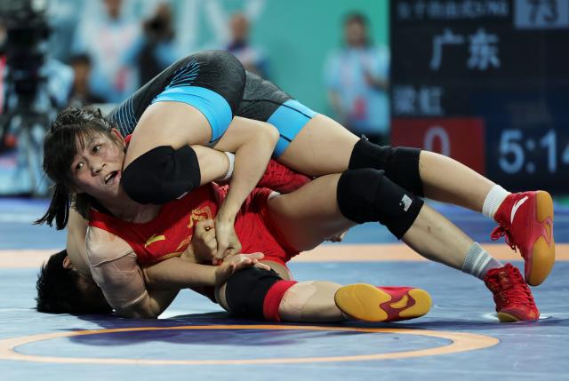 (251110) -- QINGYUAN, Nov. 10, 2025 (Xinhua) -- Hong Kexin (top) of Jiangsu competes against Liang Hong of Guangdong during the women's freestyle 57kg final match of wrestling at China's 15th National Games in Qingyuan, south China's Guangdong Province, Nov. 10, 2025. (Xinhua/Li Ran)