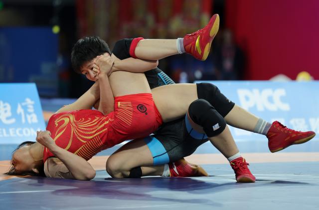 (251110) -- QINGYUAN, Nov. 10, 2025 (Xinhua) -- Hong Kexin (back) of Jiangsu competes against Liang Hong of Guangdong during the women's freestyle 57kg final match of wrestling at China's 15th National Games in Qingyuan, south China's Guangdong Province, Nov. 10, 2025. (Xinhua/Li Ran)