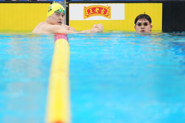 (251111) -- SHENZHEN, Nov. 11, 2025 (Xinhua) -- Sun Yang (L) of Zhejiang shakes hands with teammate Pan Zhanle after the men's 200m freestyle preliminary of swimming event at China's 15th National Games in Shenzhen, south China's Guangdong Province, Nov. 11, 2025. (Xinhua/Xue Yuge)