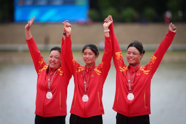 (251111) -- GUANGZHOU, Nov. 11, 2025 (Xinhua) -- Silver medalists Xie Lingli (C)/Zhang Xinyu (R) of Jiangxi pose with their coach during the awarding ceremony after the women's double sculls final of rowing at China's 15th National Games in Guangzhou, south China's Guangdong Province, Nov. 11, 2025. (Xinhua/Pan Yulong)