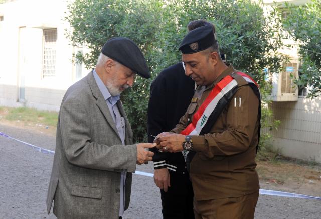 (251111) -- BAGHDAD, Nov. 11, 2025 (Xinhua) -- A member of Iraqi security forces checks a voter's identity information at a polling center in Baghdad, Iraq, on Nov. 11, 2025. Iraqis began to vote in parliamentary elections on Tuesday morning for a new 329-member Council of Representatives. (Xinhua/Khalil Dawood)