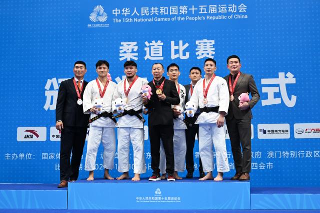 (251111) -- ZHAOQING, Nov. 11, 2025 (Xinhua) -- Gold medalist Qing Daga of Inner Mongolia and silver medalist Wang Youliang of Shandong, along with bronze medalists Li Jinhang of Beijing and Saiyin-Erideni of Gansu pose with their coaches during the awarding ceremony for Judo men's -73kg at China's 15th National Games in Zhaoqing, south China's Guangdong Province, Nov. 11, 2025. (Xinhua/Zhu Xiang)