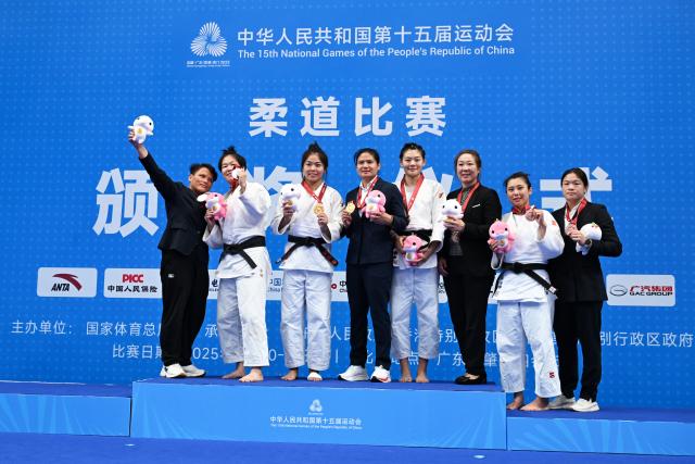 (251111) -- ZHAOQING, Nov. 11, 2025 (Xinhua) -- Gold medalist Sun Xiaoqian of Shandong and silver medalist Zhang Yiming of Hubei, along with bronze medalists Liu Lu and Sun Anqi, both from Guangdong, pose with their coaches during the awarding ceremony for the Judo women's -70kg at China's 15th National Games in Zhaoqing, south China's Guangdong Province, Nov. 11, 2025. (Xinhua/Zhu Xiang)