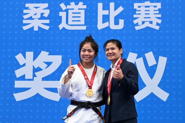 (251111) -- ZHAOQING, Nov. 11, 2025 (Xinhua) -- Gold medalist Sun Xiaoqian of Shandong poses with her coach during the awarding ceremony for the Judo women's -70kg at China's 15th National Games in Zhaoqing, south China's Guangdong Province, Nov. 11, 2025. (Xinhua/Zhu Xiang)