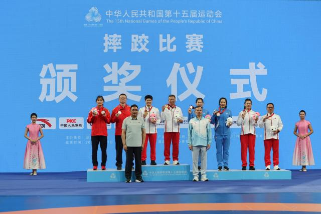 (251111) -- QINGYUAN, Nov. 11, 2025 (Xinhua) -- Gold medalist Long Jia of Yunnan, silver medalist Han Yue of Jiangsu, bronze medalist Zhou Feng of Liaoning and bronze medalist Li Zelu of Yunnan pose with their coaches during the awarding ceremony after the women's freestyle 68kg of wrestling at China's 15th National Games in Qingyuan, south China's Guangdong Province, Nov. 11, 2025. (Xinhua/Li Ran)