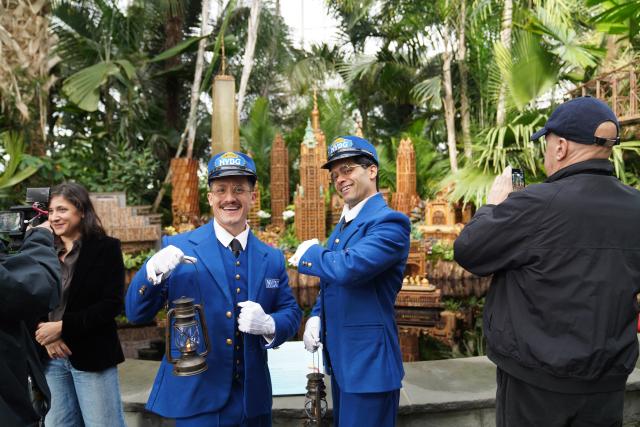 (251111) -- NEW YORK, Nov. 11, 2025 (Xinhua) -- Staff members dressed up as train conductors greet visitors in front of the models of Manhattan buildings during a preview of the Holiday Train Show at New York Botanical Garden in New York, the United States, on Nov. 11, 2025. A preview for the Holiday Train Show, which is open to the public from Nov. 15, 2025 to Jan. 11, 2026, was held at the New York Botanical Garden on Tuesday, showcasing large-scale model trains running in a miniature New York City where nearly 200 scaled iconic buildings and structures are recreated using bark, leaves and other natural materials. (Xinhua/Zhang Fengguo)