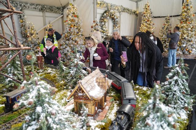 (251111) -- NEW YORK, Nov. 11, 2025 (Xinhua) -- Visitors take photos of model trains during a preview of the Holiday Train Show at New York Botanical Garden in New York, the United States, on Nov. 11, 2025. A preview for the Holiday Train Show, which is open to the public from Nov. 15, 2025 to Jan. 11, 2026, was held at the New York Botanical Garden on Tuesday, showcasing large-scale model trains running in a miniature New York City where nearly 200 scaled iconic buildings and structures are recreated using bark, leaves and other natural materials. (Xinhua/Zhang Fengguo)