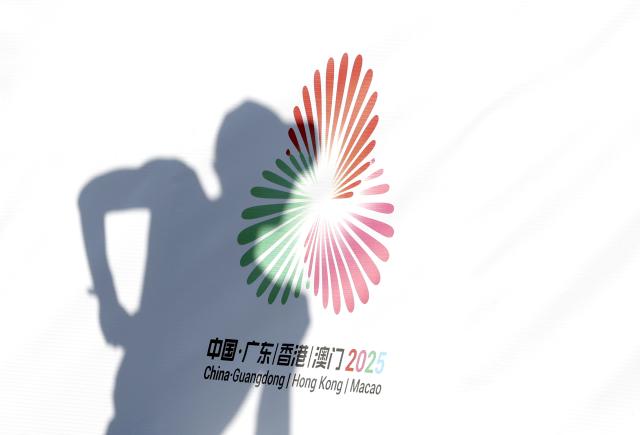 (251112) -- ZHUHAI, Nov. 12, 2025 (Xinhua) -- An athlete passes by the logo of China's 15th National Games while competing during the men's 20km race walk of athletics at China's 15th National Games in Zhuhai, south China's Guangdong Province, Nov. 12, 2025. (Xinhua/Mao Siqian)