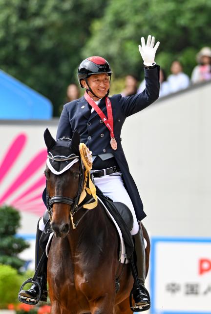 (251112) -- SHENZHEN, Nov. 12, 2025 (Xinhua) -- Bronze medalist Gu Bing of Guangdong greets the spectators after winning the equestrian dressage individual final at China's 15th National Games in Shenzhen, south China's Guangdong Province, Nov. 12, 2025. (Xinhua/Feng Kaihua)