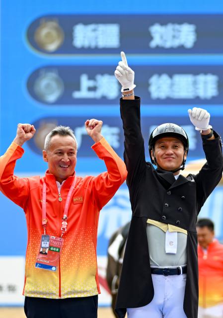 (251112) -- SHENZHEN, Nov. 12, 2025 (Xinhua) -- Gold medalist Liu Tao (R) of Xinjiang celebrates with his coach during the awarding ceremony for the equestrian dressage individual final at China's 15th National Games in Shenzhen, south China's Guangdong Province, Nov. 12, 2025. (Xinhua/Feng Kaihua)