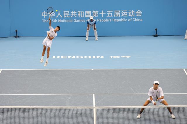 (251112) -- HENGQIN, Nov. 12, 2025 (Xinhua) -- Song Yuqiao/Zhang Boxiong (L) of Beijing compete in the men's doubles match against Chen Xianfeng/Xu Kuangqing of Jiangsu during the junior men's team final of tennis between Beijing and Jiangsu at China's 15th National Games in Hengqin, south China's Guangdong Province, Nov. 12, 2025. (Xinhua/Zhang Chenlin)