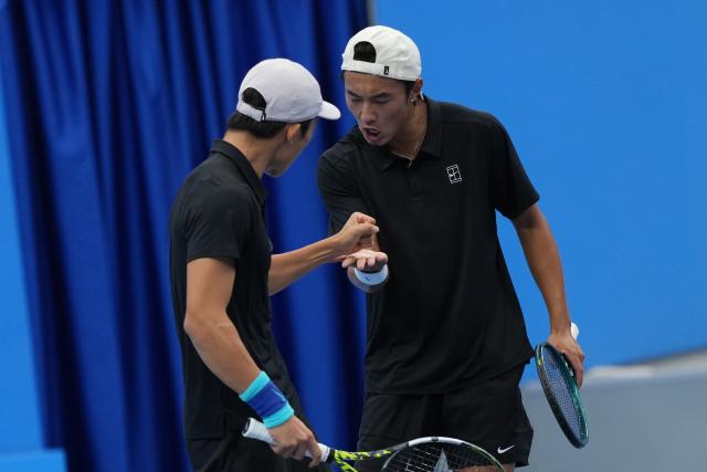 (251112) -- HENGQIN, Nov. 12, 2025 (Xinhua) -- Chen Xianfeng/Xu Kuangqing (R) of Jiangsu celebrate scoring in the men's doubles match against Song Yuqiao/Zhang Boxiong of Beijing during the junior men's team final of tennis between Beijing and Jiangsu at China's 15th National Games in Hengqin, south China's Guangdong Province, Nov. 12, 2025. (Xinhua/Yan Linyun)