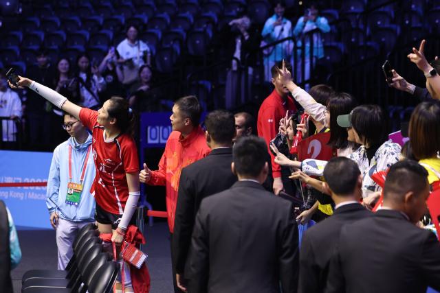 (251112) -- MACAO, Nov. 12, 2025 (Xinhua) -- Zhu Ting of Henan (2nd L) takes a selfie with fans after women's volleyball group A match between Henan and Beijing at China's 15th National Games in Macao, south China, Nov. 12, 2025. (Xinhua/Chen Bin)