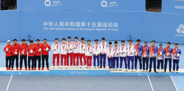 (251112) -- HENGQIN, Nov. 12, 2025 (Xinhua) -- Gold medalists team Beijing (2nd L), silver medalists team Jiangsu (1st L) and bronze medalists team Hong Kong (2nd R) and team Guangxi pose during the awarding ceremony for the junior men's team final of tennis at China's 15th National Games in Hengqin, south China's Guangdong Province, Nov. 12, 2025. (Xinhua/Zhang Chenlin)