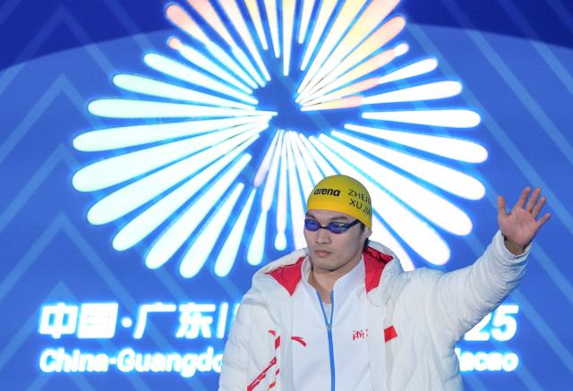 (251112) -- SHENZHEN, Nov. 12, 2025 (Xinhua) -- Xu Jiayu of Zhejiang greets the spectators before the men's 100m backstroke final of swimming at China's 15th National Games in Shenzhen, south China's Guangdong Province, Nov. 12, 2025. (Xinhua/Du Yu)
