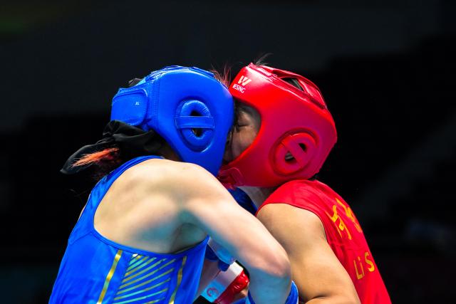 (251112) -- SHENZHEN, Nov. 12, 2025 (Xinhua) -- Yu Lisai (L) of Beijing Sport University competes against Li Shu of Henan during the women's 66 kg final of boxing at China's 15th National Games in Shenzhen, south China's Guangdong Province, Nov. 12, 2025. (Xinhua/Peng Yikai)