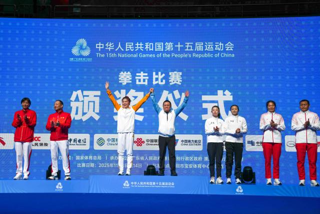 (251112) -- SHENZHEN, Nov. 12, 2025 (Xinhua) -- Gold medalist Yu Lisai of Beijing Sport University and her coach wave during the awarding ceremony for the women's 66kg final of boxing at China's 15th National Games in Shenzhen, south China's Guangdong Province, Nov. 12, 2025. (Xinhua/Peng Yikai)