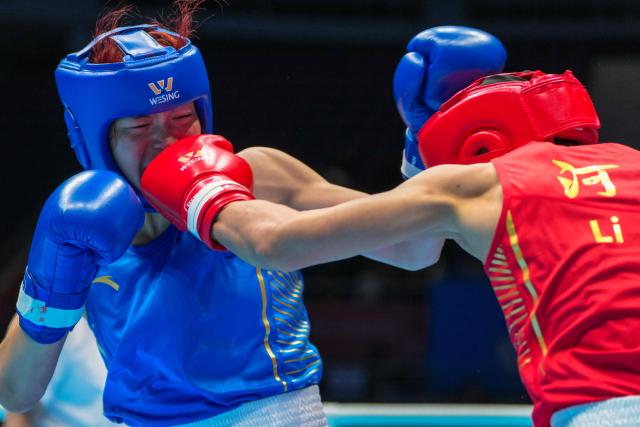 (251112) -- SHENZHEN, Nov. 12, 2025 (Xinhua) -- Yu Lisai (L) of Beijing Sport University competes against Li Shu of Henan during the women's 66 kg final of boxing at China's 15th National Games in Shenzhen, south China's Guangdong Province, Nov. 12, 2025. (Xinhua/Peng Yikai)