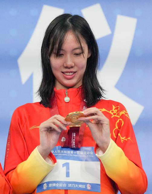 (251112) -- SHENZHEN, Nov. 12, 2025 (Xinhua) -- Gold medalist Peng Xuwei of Hubei looks at her medal during the awarding ceremony for the women's 100m backstroke of swimming at China's 15th National Games in Shenzhen, south China's Guangdong Province, Nov. 12, 2025. (Xinhua/Xue Yuge)