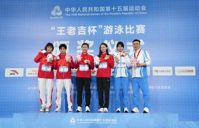 (251112) -- SHENZHEN, Nov. 12, 2025 (Xinhua) -- Gold medalist Li Bingjie of Hebei, silver medalist Wu Ruoxin of Henan and bronze medalist Mao Yihan of Zhejiang pose with their coaches during the awarding ceremony for the women's 1500m freestyle of swimming at China's 15th National Games in Shenzhen, south China's Guangdong Province, Nov. 12, 2025. (Xinhua/Xue Yuge)