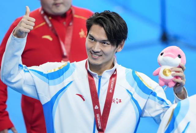 (251112) -- SHENZHEN, Nov. 12, 2025 (Xinhua) -- Gold medalist Xu Jiayu of Zhejiang greets the spectators after the awarding ceremony for the men's 100m backstroke of swimming at China's 15th National Games in Shenzhen, south China's Guangdong Province, Nov. 12, 2025. (Xinhua/Du Yu)