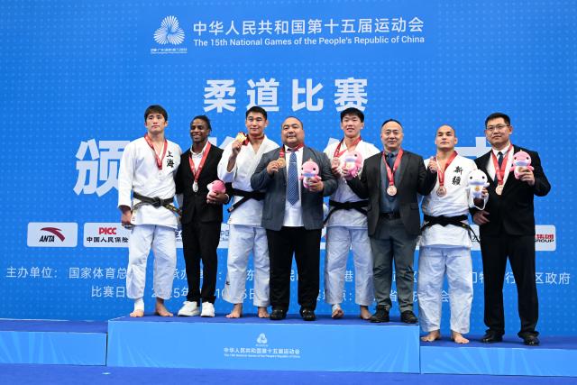 (251112) -- ZHAOQING, Nov. 12, 2025 (Xinhua) -- Gold medalist Buhebilige of Inner Mongolia and silver medalist Xie Yadong of Shanghai, along with bronze medalists Yan Boyin of Shanxi and Abudurexiti Jielili of Xinjiang pose with their coaches during the awarding ceremony for Judo men's -90kg at China's 15th National Games in Zhaoqing, south China's Guangdong Province, Nov. 12, 2025. (Xinhua/Zhu Xiang)