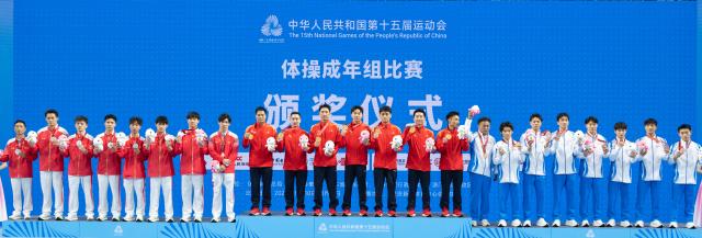 (251112) -- ZHAOQING, Nov. 12, 2025 (Xinhua) -- Gold medalists team Jiangsu, silver medalists team Hunan and bronze medalists team Zhejiang pose during the awarding ceremony for artistic gymnastics men's team final at China's 15th National Games in Zhaoqing, south China's Guangdong Province, Nov. 12, 2025. (Xinhua/Du Zixuan)