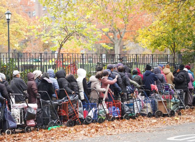(251112) -- NEW YORK, Nov. 12, 2025 (Xinhua) -- People line up to get free food items at a distribution station in New York, the United States, on Nov. 12, 2025. People received free food items from a distribution station of the Food Bank for New York city on Wednesday. (Xinhua/Zhang Fengguo)